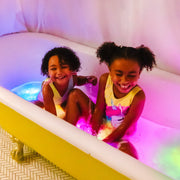 Two children playing in bathtub with colorful glowing Glo Pals light-up toys