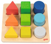 A wooden shape-sorting toy board with colorful geometric blocks, including red, green, blue, orange, light blue, yellow, and white pieces, on a plain white background. The brand name 'goki' is printed in red on the bottom right corner of the wooden board.