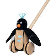 A wooden toy penguin walker with a natural wood body and wheels, a black felt head and wings, light blue painted fish and tuft, and a natural wood handle on a white background.