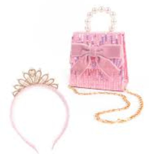 A pink toy handbag set with a sequined body, satin bow, pearl handle, gold chain strap, and a matching tiara headband on a white background.