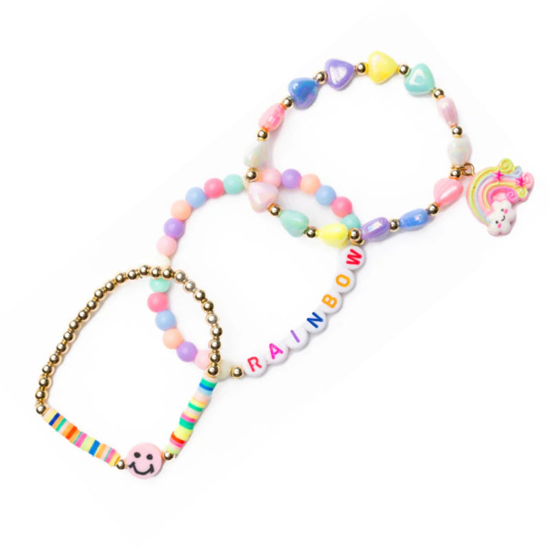 Three pastel beaded bracelets with gold-tone metal links, including a rainbow letter bracelet spelling 'RAINBOW', a unicorn charm bracelet, and a striped charm bracelet, shown on a white background.