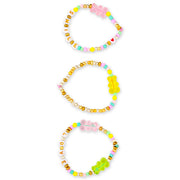 Three colorful beaded bracelets with letter beads and gummy bear charms on white background