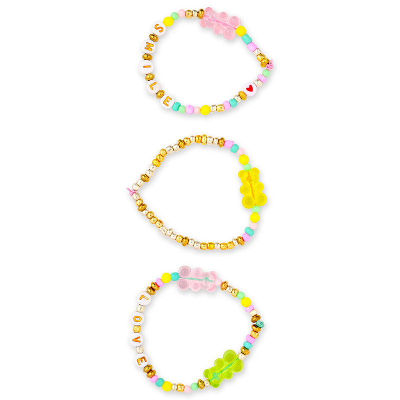 Three colorful beaded bracelets with letter beads and gummy bear charms on white background