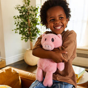 Child holding the 13.5-inch Mo Willems' Piggie plush for scale