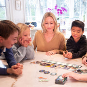 Family playing Feelin Cute board game together around kitchen table