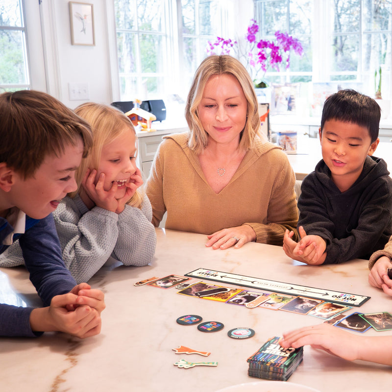 Family playing Feelin Cute board game together around kitchen table