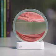 Circular LED sand art display with pink colored sand creating landscape patterns on white base