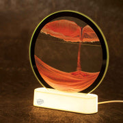 Illuminated circular sand art display with orange sand patterns on white LED base