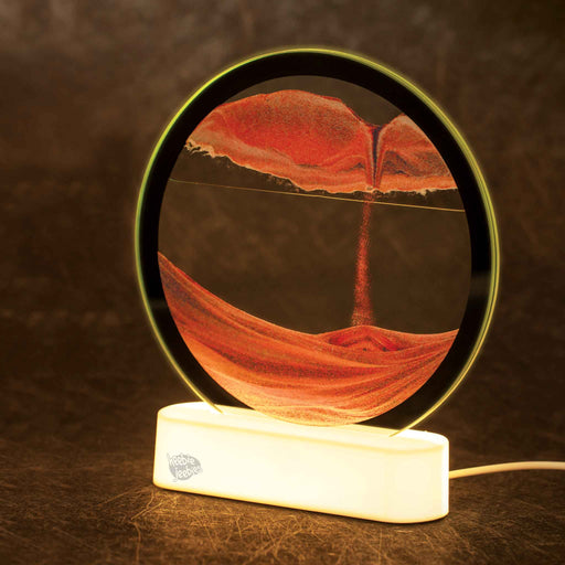 Illuminated circular sand art display with orange sand patterns on white LED base