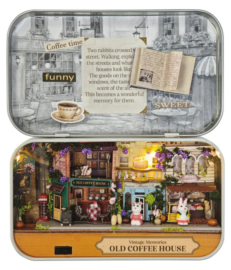 A charming vintage café village with the Old Coffee House DIY Tiniature Kit. This project features a pair of adorable rabbit figurineson a white background.
