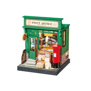 Miniature dollhouse post office building with green exterior, red mailbox, and detailed interior furnishings