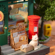 Century Post Office miniature diorama with red postbox, white cat, and postal accessories