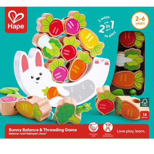 Hape Bunny Balance & Threading Game wooden toy set on a teal background, showing colorful carrot and vegetable pieces, a white bunny figure, packaging window view, and age 2-6 years text.