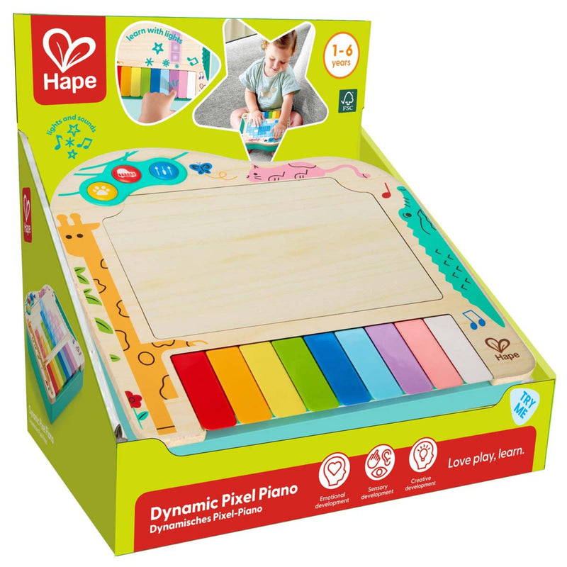 Hape Dynamic Pixel Piano toy in its original retail packaging, featuring a wooden writing pad and colorful piano keys.