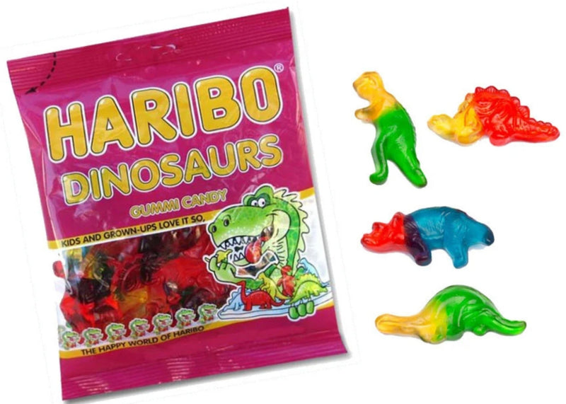 A bag of Haribo Dinosaurs gummi candy next to four colorful dinosaur-shaped gummy candies on a white background.