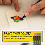 Person coloring a tattoo design on a small piece of paper with markers, accompanied by promotional text for a tattoo-making kit.
