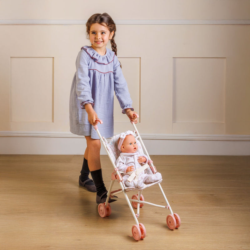 Child pushing the pink Bonbebé umbrella stroller with a baby doll seated inside.