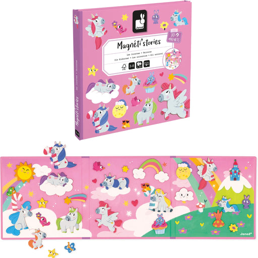 A children's magnetic storytelling set shown in pink and an unfolded displaying colorful unicorn, rainbow, sun, clouds, and fantasy landscape scenes. The set includes small loose magnets and stickers on a clean white background.