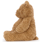 Left side view of classic Teddy Bear Bartholomew from Jellycat.  Light brown color, soft plush fur on white background.