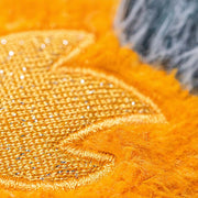 Close up picture of embroidery on orange plush over left eye of Jellycat's  Space Comet.