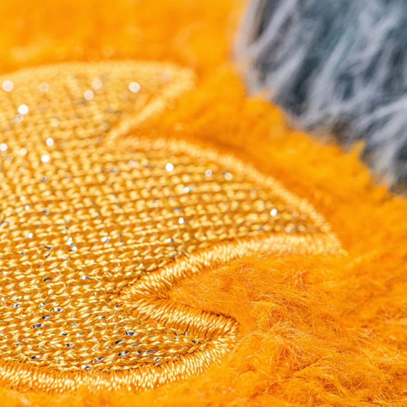 Close up picture of embroidery on orange plush over left eye of Jellycat's  Space Comet.