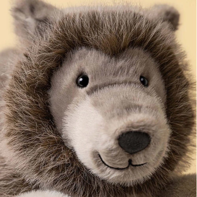 Ulrich Wolf from Jellycat is looking relaxed.  He's got black eyes and a bit of a mane around his face with a pleasant smile. 