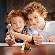 Two children playing with the KidzLab pocket volcano on a table.