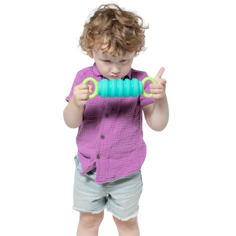 Child holding a green and blue Krumples Pully toy against a white background.
