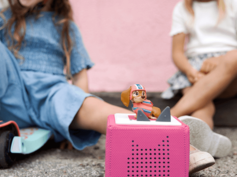 Paw Patrol Liberty Tonie figure on pink Toniebox speaker with children playing in background