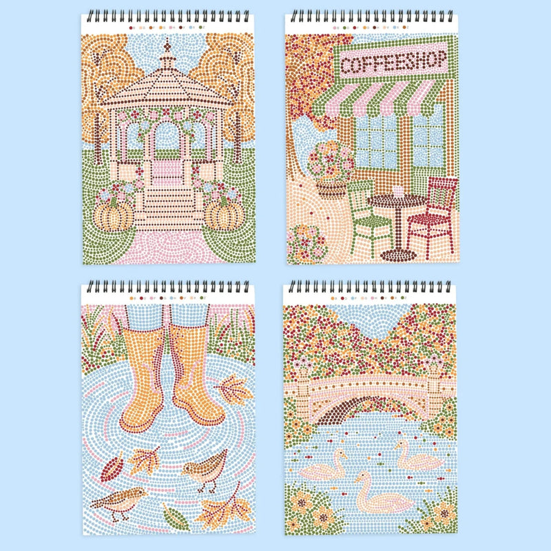 Four spiral-bound art books or notebooks arranged in a 2x2 grid on a light blue background. Each features a colorful mosaic-style illustration: a gazebo with pumpkins, a coffee shop exterior, rain boots in a puddle with birds, and a bridge over water with swans.