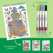Coloring book with a cup design, markers, and additional pages on a green background