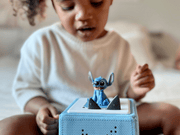 Child playing with blue Stitch Tonie figure on Toniebox audio system