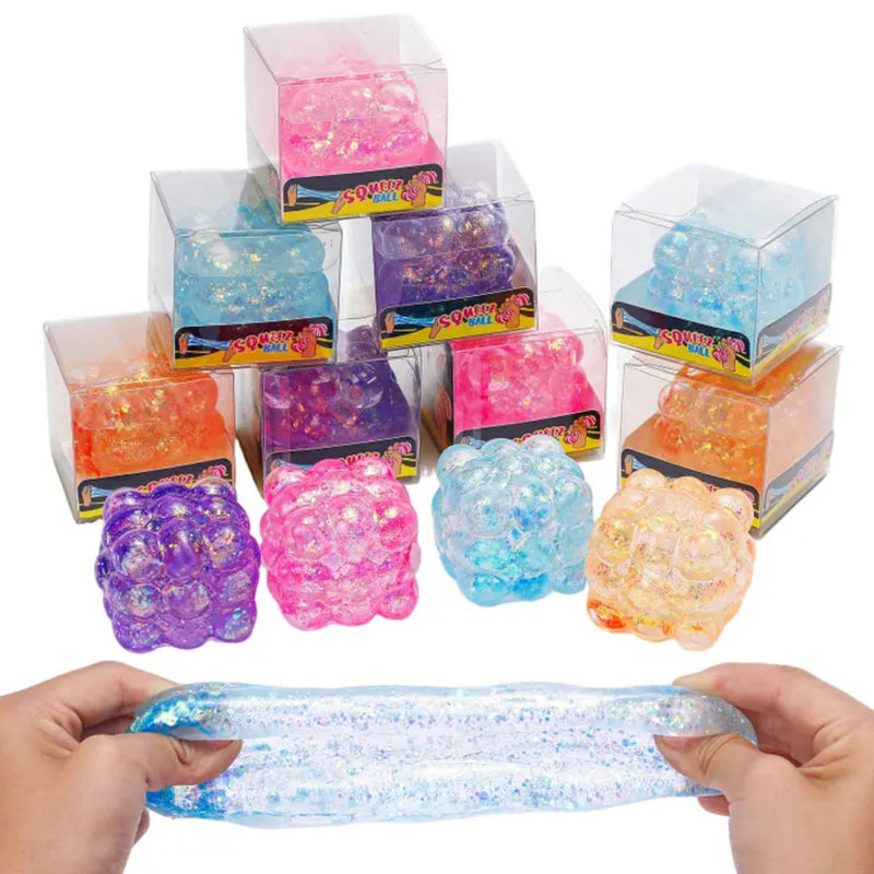 Glitter bubble cube sensory fidget toys in assorted colors with one stretched in hands.
