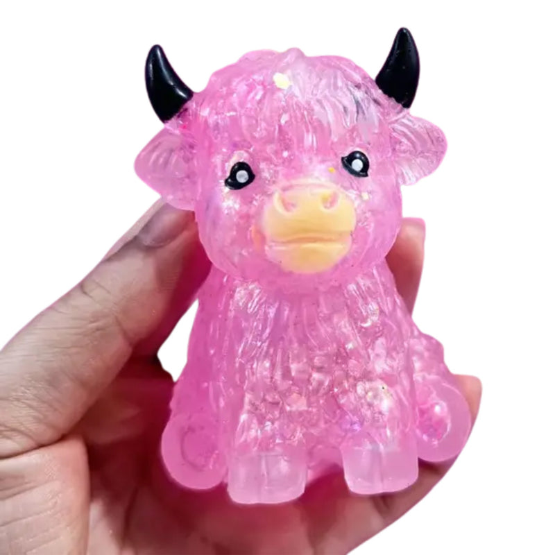 Pink glitter Highland cow squishy toy held in hand