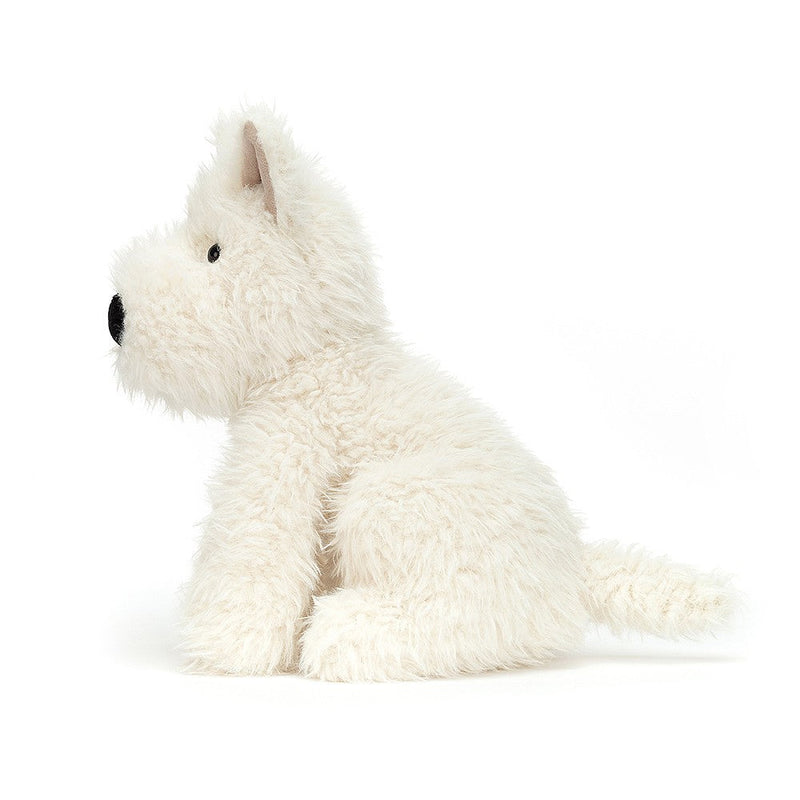 Cream colored fluffy Jellycat Munro Scottie Dog plush toy sitting on white background