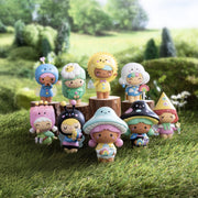 Colorful Momiji Magical Meadow blind box figures displayed on wooden logs in grassy outdoor setting