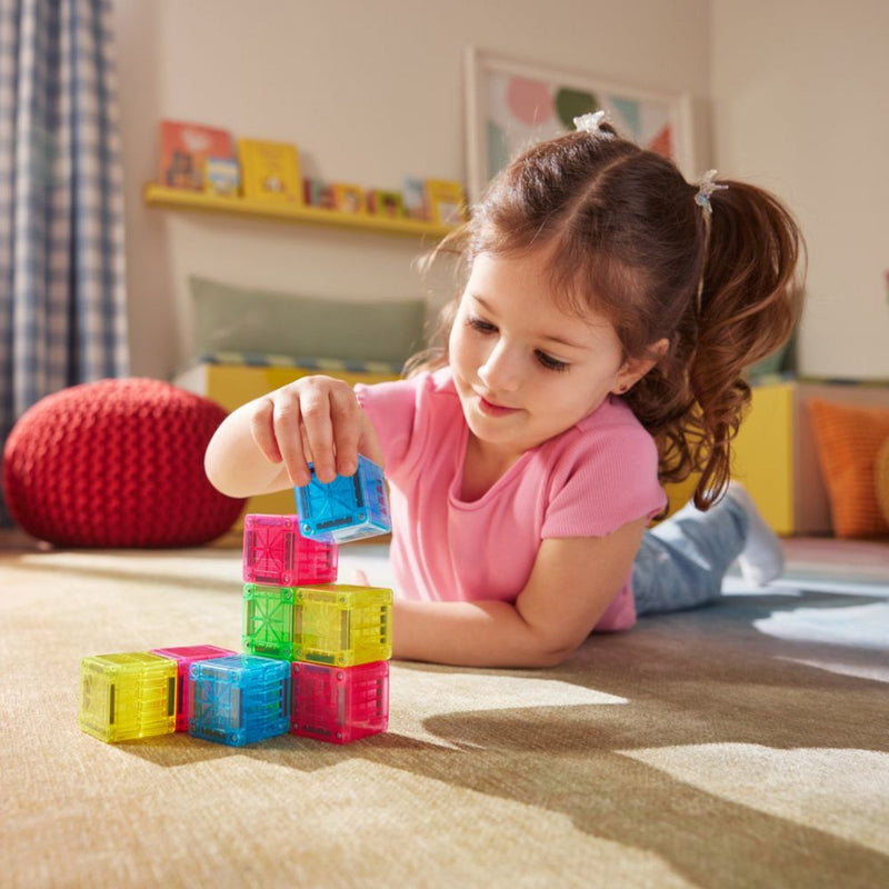 Child playing with colorful building blocks on a carpeted floor.