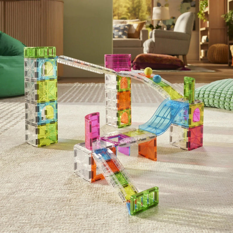 Colorful magnetic building blocks on a carpeted floor with a living room in the background