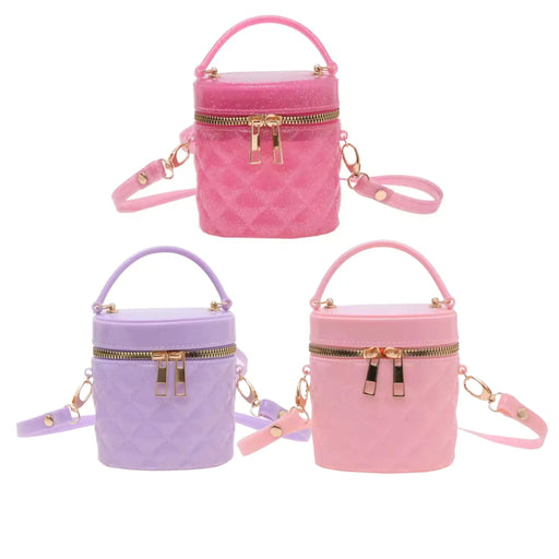 Three quilted cylindrical handbag charms in pink, purple, and light pink, each with a top handle, zippered front, and detachable shoulder strap, shown on a plain white background.