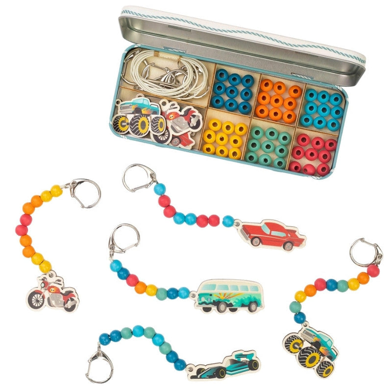 Colorful keychains with vehicle charms and a tin of beads on a white background