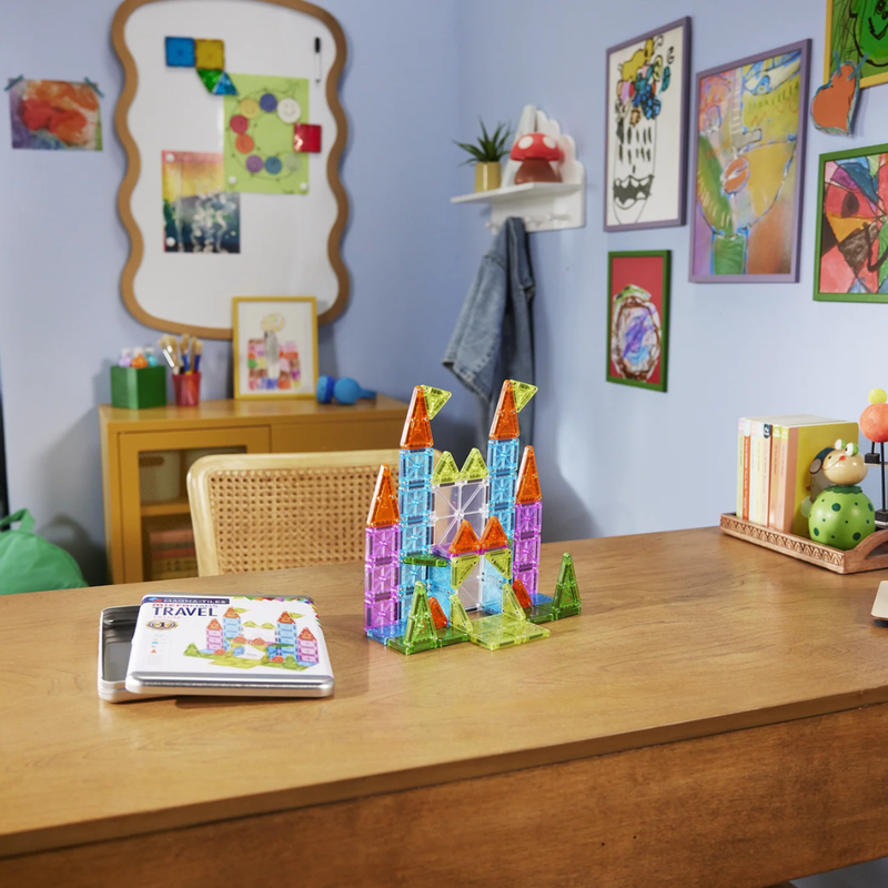 Colorful magnetic building blocks on a wooden table with a child's room in the background.
