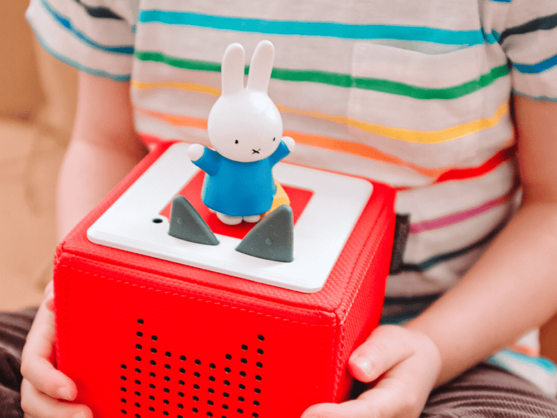 Child holding red Toniebox with white Miffy character figurine on top