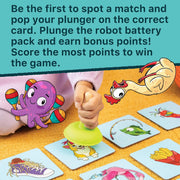 A children's matching game board with illustrated cards and a hand using a green plunger to pop matchboxes. The scene includes a large instruction text panel at the top and cartoon animal graphics overlaid on the image.