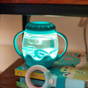 Lighted Mini Sensory Jar from Glo pals.  Filled with water and light resting on a stack of kids books.