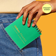 Hand holding green Lifelines FlowArt notebook in jeans pocket showing pocket-sized portability