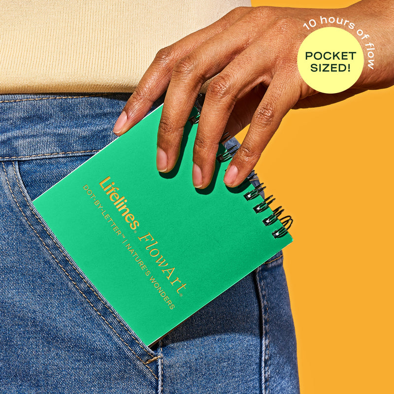 Hand holding green Lifelines FlowArt notebook in jeans pocket showing pocket-sized portability