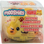 MOOSHIES Kitten Dumplings toy in its original clear plastic packaging, featuring a yellow plush dumpling character with black eyes and a black whisker, surrounded by colorful product text and warning labels.