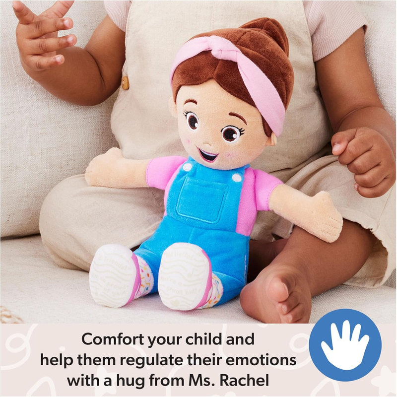 Plush toy (Ms. Rachel) resembling a child in blue overalls and pink shirt held by a child