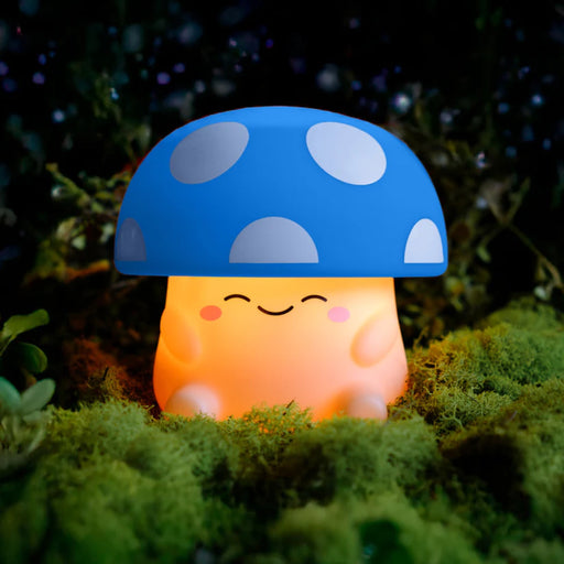 Mushroom-shaped night light with a blue cap and off white body on a grassy background.