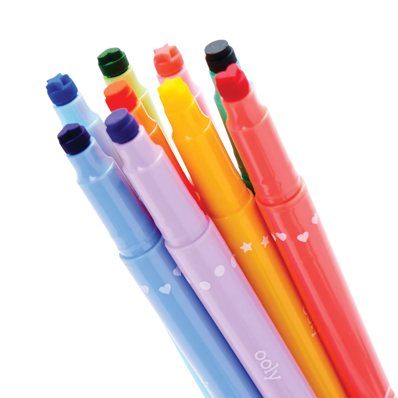 Four colorful double-ended markers with decorative heart and star patterns on black background